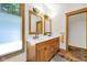 Bright bathroom featuring a double sink vanity with wood cabinets and framed mirrors at 9722 N Gasburg Rd, Mooresville, IN 46158