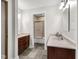 Bathroom featuring double sinks, mirrors, and a shower/tub combo, accented by neutral tile and modern lighting at 9722 N Gasburg Rd, Mooresville, IN 46158