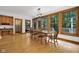 A dining room has wood floors, a wooden table with seating, and large windows looking out to the outdoors at 9722 N Gasburg Rd, Mooresville, IN 46158