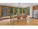 A dining room with wood floors, a wooden table with seating, and large windows overlooking the outdoors at 9722 N Gasburg Rd, Mooresville, IN 46158