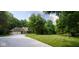 The charming yellow home is nestled amongst lush trees, featuring a well-manicured lawn and a long, winding driveway at 9722 N Gasburg Rd, Mooresville, IN 46158