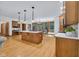 Open-concept kitchen with an island, hardwood floors, modern lighting, and views to the lush backyard provides an ideal space at 9722 N Gasburg Rd, Mooresville, IN 46158