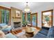 A living room features a stone fireplace, hardwood floors, and windows looking out to a wooded area at 9722 N Gasburg Rd, Mooresville, IN 46158