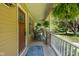 Cozy covered porch features rocking chairs, hanging ferns, and a decorative wooden door, creating a welcoming outdoor space at 9722 N Gasburg Rd, Mooresville, IN 46158