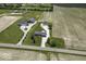Stunning aerial view of a home with two additional outbuildings, surrounded by lush green grass and agricultural fields at 10769 Shelbyville Rd, Indianapolis, IN 46259
