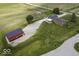 Aerial view of a home with a barn, long driveway, brick exterior, and well manicured lawn at 10769 Shelbyville Rd, Indianapolis, IN 46259