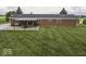 Backyard view of brick home with a patio, pergola, and lush green grass at 10769 Shelbyville Rd, Indianapolis, IN 46259