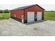 Red and black barn with a door and two garage doors and a gravel driveway at 10769 Shelbyville Rd, Indianapolis, IN 46259