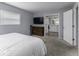 Bedroom featuring a TV, wood dresser, and an open door to bathroom at 10769 Shelbyville Rd, Indianapolis, IN 46259