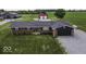 Aerial view of a brick home with a dark garage door, set against a lush green lawn at 10769 Shelbyville Rd, Indianapolis, IN 46259