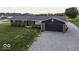 A well-maintained brick house features a dark garage door, set against a lush green lawn at 10769 Shelbyville Rd, Indianapolis, IN 46259
