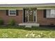 Exterior shot of a brick home featuring a welcoming front door, sidelights, and decorative wreath at 10769 Shelbyville Rd, Indianapolis, IN 46259