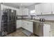 Kitchen featuring stainless steel refrigerator and appliances with white cabinetry and brown countertops at 10769 Shelbyville Rd, Indianapolis, IN 46259