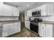 Kitchen with stainless steel oven, range and microwave with white cabinetry and brown countertops at 10769 Shelbyville Rd, Indianapolis, IN 46259
