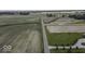 Aerial view of farmland with road bisecting rows of crops and adjacent homesites at 10769 Shelbyville Rd, Indianapolis, IN 46259