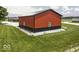 Exterior angle shot of a metal red and black outbuilding with well-maintained yard at 10769 Shelbyville Rd, Indianapolis, IN 46259