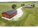 Exterior angle shot of a metal red and black outbuilding with well-maintained yard at 10769 Shelbyville Rd, Indianapolis, IN 46259