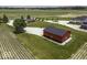 Exterior shot of red and black outbuilding with grey roof in a rural setting with grassy lawn at 10769 Shelbyville Rd, Indianapolis, IN 46259