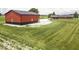 Exterior view of a modern red and black outbuilding with black roof and manicured lawn in a rural setting at 10769 Shelbyville Rd, Indianapolis, IN 46259