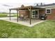 A wooden pergola covers a brick patio with a dining table and grill, perfect for outdoor entertaining at 10769 Shelbyville Rd, Indianapolis, IN 46259