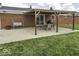 View of backyard brick patio with dining set and swing under a wood pergola at 10769 Shelbyville Rd, Indianapolis, IN 46259