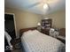 A bedroom with a patterned bedspread, a ceiling fan, and a bookshelf with a lamp on top at 10780 Affirmed Dr, Indianapolis, IN 46234