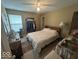 A bedroom with a patterned bedspread, ceiling fan, and a vintage-style vanity with a fan at 10780 Affirmed Dr, Indianapolis, IN 46234