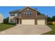 Charming two-story home with a well-manicured lawn, brick facade, and attached two-car garage at 10780 Affirmed Dr, Indianapolis, IN 46234