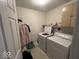 Well-lit laundry room features a washer, dryer, utility sink, and built-in shelving at 10780 Affirmed Dr, Indianapolis, IN 46234