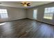 Bright living room featuring modern flooring, neutral walls, and natural light from two windows at 10891 Sweetsen Rd, Camby, IN 46113
