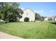 View of the lush green backyard with mature trees and well-maintained lawn at 10949 Haig Point Dr, Fishers, IN 46037
