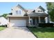 Charming two-story home featuring a brick and siding facade, attached garage, and a well-manicured front lawn at 10949 Haig Point Dr, Fishers, IN 46037