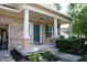 Charming brick home with a covered front porch, green door and lovely landscaping at 10949 Haig Point Dr, Fishers, IN 46037