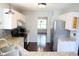 Well-lit kitchen with granite countertops, stainless steel appliances, white cabinets, and hardwood flooring at 10949 Haig Point Dr, Fishers, IN 46037
