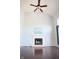 Bright living room features a fireplace, large windows, a ceiling fan, and gleaming hardwood floors at 10949 Haig Point Dr, Fishers, IN 46037