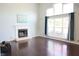 Bright living room features a fireplace, large windows with curtains, and gleaming hardwood floors at 10949 Haig Point Dr, Fishers, IN 46037