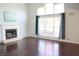 Bright living room features a fireplace, large windows with curtains, and gleaming hardwood floors at 10949 Haig Point Dr, Fishers, IN 46037