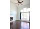 Bright living room features a fireplace, large windows, a ceiling fan, and gleaming hardwood floors at 10949 Haig Point Dr, Fishers, IN 46037