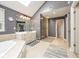 Bathroom featuring tiled floor, skylight, glass shower, and double vanity at 11350 Old Stone Dr, Indianapolis, IN 46236