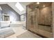 Bright bathroom featuring tiled floor, skylight, glass shower with bench, and a soaking tub at 11350 Old Stone Dr, Indianapolis, IN 46236