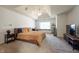 Spacious bedroom with a large bed, tray ceiling, and a window seat at 11350 Old Stone Dr, Indianapolis, IN 46236