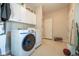Laundry area with washer and dryer, storage cabinets, and tiled floor at 11350 Old Stone Dr, Indianapolis, IN 46236