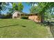 Serene backyard with mature trees, sprawling lawn, and a charming home exterior at 1302 N Furman Ave, Indianapolis, IN 46214