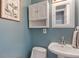 Charming bathroom featuring a pedestal sink, coordinated wall cabinet, and delightful decorative art at 1302 N Furman Ave, Indianapolis, IN 46214