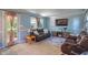 Comfortable living room features a leather sofa, a TV, and neutral-toned walls and carpet at 1302 N Furman Ave, Indianapolis, IN 46214