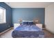 Cozy bedroom with a blue accent wall, carpeted floors, and natural light from the window at 16235 Natures Way, Westfield, IN 46074