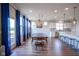 Open floor plan dining room with modern chandelier, hardwood floors, leading to the kitchen and island seating at 16235 Natures Way, Westfield, IN 46074