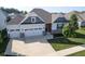 Charming home featuring a three-car garage, manicured lawn, and inviting entrance at 16235 Natures Way, Westfield, IN 46074
