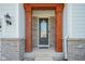Close-up of the elegant front door, showing craftsman columns and brick accents at 16235 Natures Way, Westfield, IN 46074
