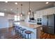 Contemporary kitchen with white cabinets, an island with seating, and stainless steel appliances at 16235 Natures Way, Westfield, IN 46074
